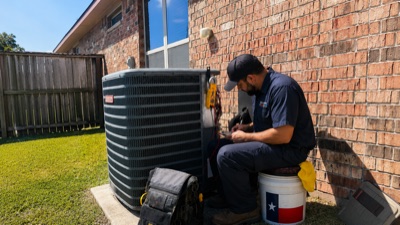 HVAC technician repairing residential AC unit
